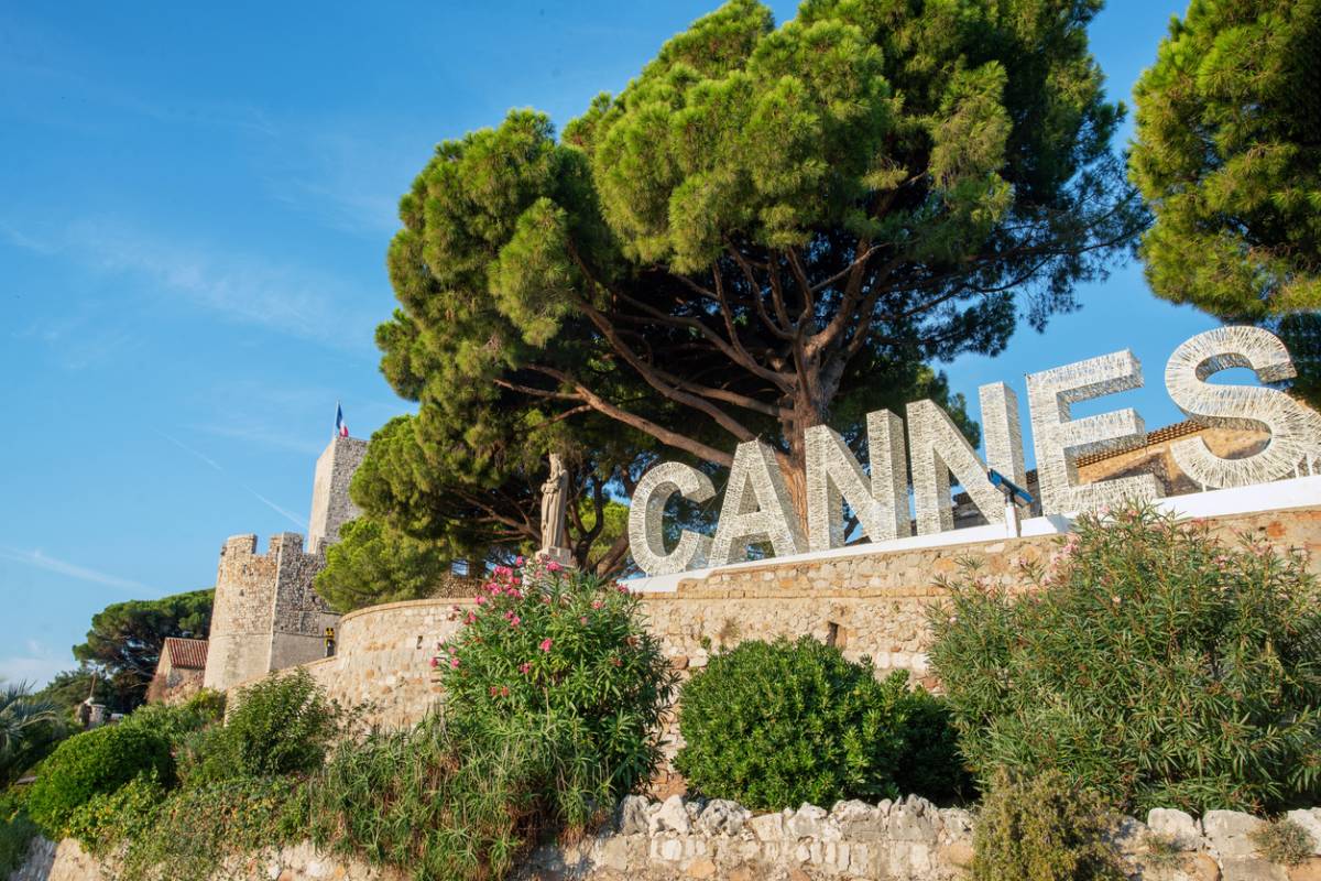 Enseigne Cannes avec château en arrière-plan.